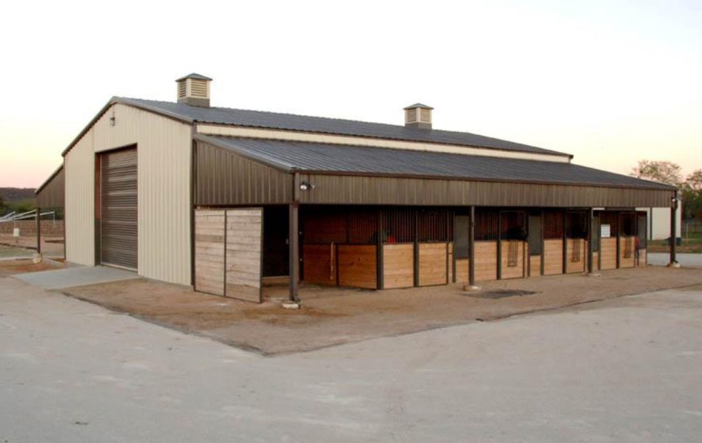 Brown steel building with stables and ridge decor vents and awning