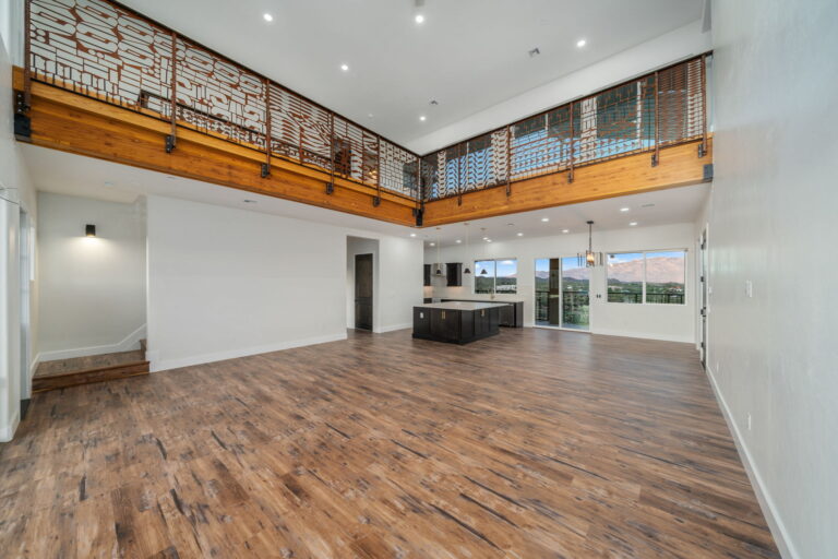 Finished open-plan interior with exposed wood beams and an upper-level railing